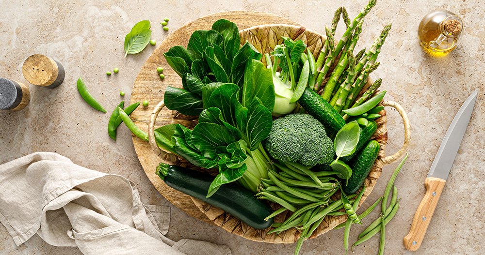 Cesto in vimini con verdure verdi fresche.